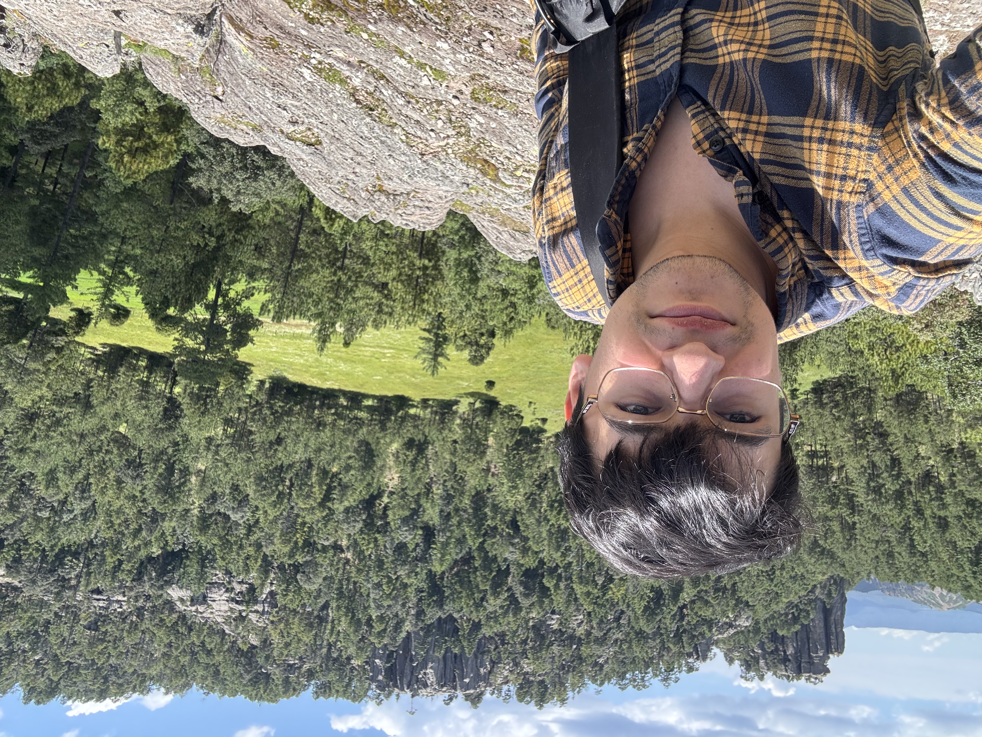 Emmanuel Cázarez outdoors, with forested mountains in the background